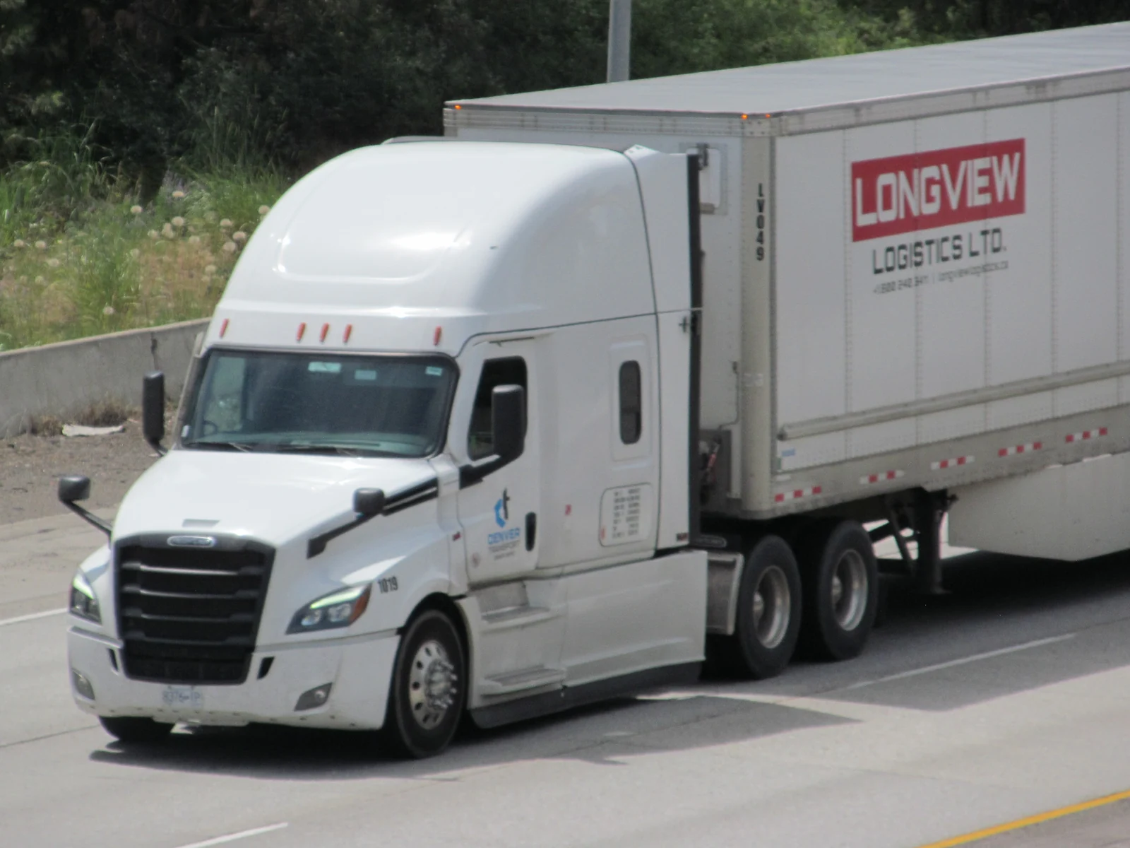 White Freightliner tractor with a box trailer on Interstate 90 in Washington